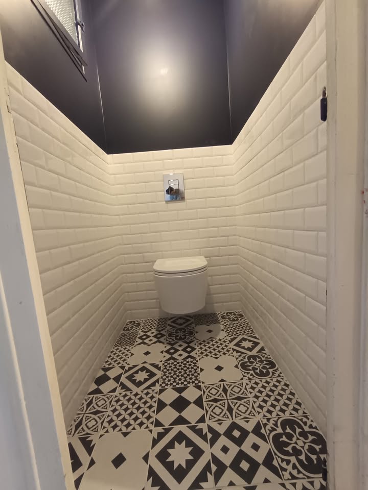 Photo réelle — Toilettes rénovées : WC suspendu et carrelage métro à Localisation non précisée