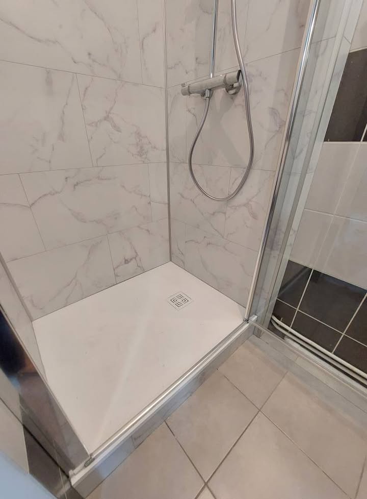 Photo réelle — Espace douche : habillage mural clair et paroi vitrée à Localisation non précisée