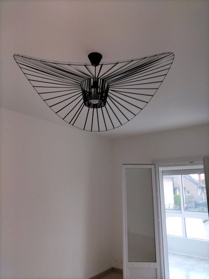 Photo réelle — Pièce de vie : sol d’aspect bois et luminaires à Localisation non précisée