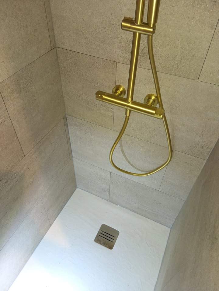 Photo réelle — Salle de bains : robinetterie dorée et effet pierre à Localisation non précisée