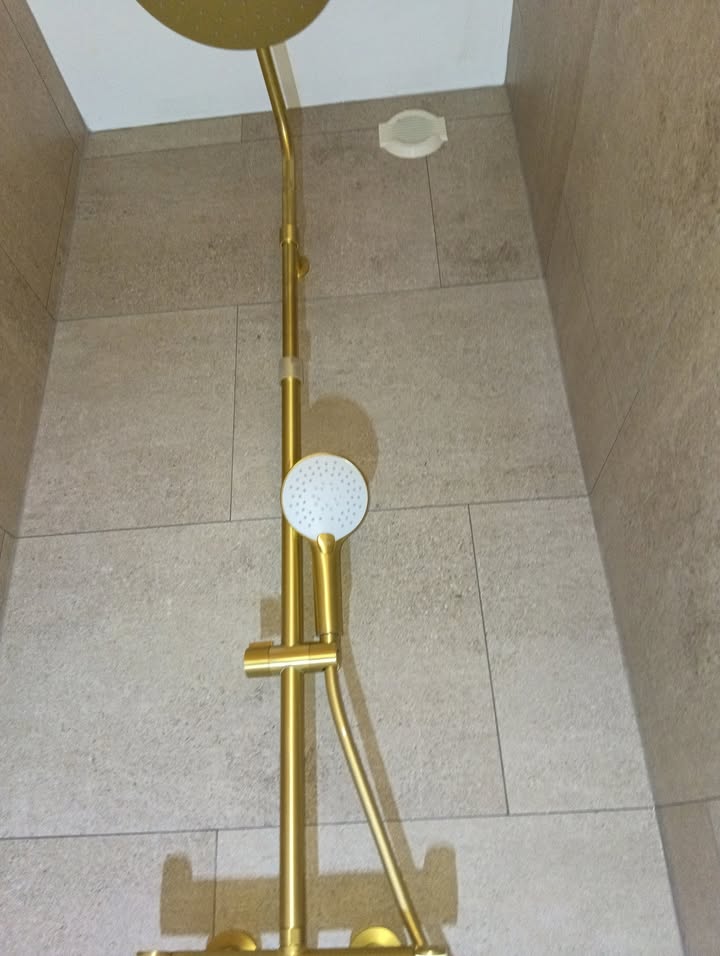 Photo réelle — Salle de bains : robinetterie dorée et effet pierre à Localisation non précisée